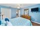 Comfortable bedroom featuring blue walls, ceiling fan, and a wooden dresser with decorative mirror at 929 Eastmont Ct, The Villages, FL 32162