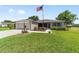 Charming single-story home featuring an American flag, well-maintained lawn and attached garage at 929 Eastmont Ct, The Villages, FL 32162