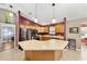 Well-lit kitchen features a center island, stainless steel appliances, wood cabinetry and tile floors at 929 Eastmont Ct, The Villages, FL 32162