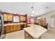 Bright kitchen boasts an island with pendant lighting, tile flooring, wood cabinets and stainless appliances at 929 Eastmont Ct, The Villages, FL 32162