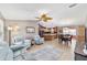 Open-concept living room with tile flooring, ceiling fan, and seamless flow to kitchen and dining area at 929 Eastmont Ct, The Villages, FL 32162