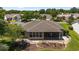 The rear exterior shows a screened-in porch, patio, lush landscaping, and a well-maintained lawn surrounding the home at 929 Eastmont Ct, The Villages, FL 32162