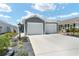 Charming home featuring a two-car garage, landscaped yard with rock detail and tasteful exterior lighting at 947 Couture St, The Villages, FL 32163