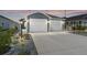 Charming home featuring a two-car garage, landscaped yard with rock detail and tasteful exterior lighting at 947 Couture St, The Villages, FL 32163