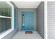 Inviting front porch with a charming blue door, shutter accents, and neutral siding at 947 Couture St, The Villages, FL 32163