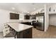 Well-equipped kitchen featuring stainless steel appliances, dark cabinets, and a breakfast bar at 947 Couture St, The Villages, FL 32163