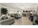 Inviting living room connects to the kitchen, features a ceiling fan and light-filled with neutral color palettes at 947 Couture St, The Villages, FL 32163