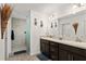 Spacious main bathroom featuring double sink vanity, decorative mirrors, and walk-in shower at 947 Couture St, The Villages, FL 32163
