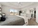 Bright main bedroom with large window, tray ceilings, white furniture, and backyard view at 947 Couture St, The Villages, FL 32163