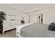 Bright main bedroom with tray ceilings, a full dresser and access to the bathroom and walk-in closet at 947 Couture St, The Villages, FL 32163