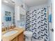 Bathroom features a vanity with a granite countertop and a shower with a patterned curtain at 9621 Se 168Th Maplesong Ln, The Villages, FL 32162