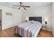 Bedroom with hardwood floors, a ceiling fan, and a padded headboard on the bed at 9621 Se 168Th Maplesong Ln, The Villages, FL 32162