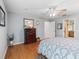 Bright bedroom featuring wood floors, a ceiling fan, and a traditional wood dresser at 9621 Se 168Th Maplesong Ln, The Villages, FL 32162