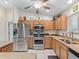 Bright kitchen features stainless steel appliances, light wood cabinetry, and a breakfast bar at 9621 Se 168Th Maplesong Ln, The Villages, FL 32162