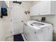 Laundry room featuring a modern washing machine, ample storage cabinets, and a utility sink at 9621 Se 168Th Maplesong Ln, The Villages, FL 32162