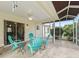 Screened in patio with tile floor, ceiling fan and seating area with chairs overlooking the lush backyard at 9621 Se 168Th Maplesong Ln, The Villages, FL 32162