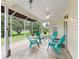 Covered and screened-in patio with tile floor, ceiling fan, and comfortable outdoor seating at 9621 Se 168Th Maplesong Ln, The Villages, FL 32162
