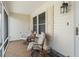 Relaxing screened porch area with tile flooring, two chairs, side table and outdoor lighting at 9621 Se 168Th Maplesong Ln, The Villages, FL 32162
