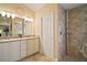 Bathroom featuring a double sink vanity, walk-in tiled shower, and neutral decor at 1606 Mount Croghan Trl, The Villages, FL 32162