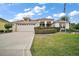 Charming one-story home with a two-car garage, manicured lawn and lush landscaping at 1606 Mount Croghan Trl, The Villages, FL 32162