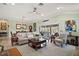 Open living room with tile floors, comfortable seating, stylish decor, and natural light through sliding glass doors at 1606 Mount Croghan Trl, The Villages, FL 32162
