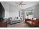 Cozy living room featuring a comfortable gray sofa, reading chair, and natural light from a window at 1606 Mount Croghan Trl, The Villages, FL 32162