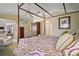 Spacious main bedroom with sitting area, hardwood floors, canopy bed, and access to other rooms at 1606 Mount Croghan Trl, The Villages, FL 32162