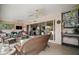 Relaxing covered patio with comfortable wicker seating, ceiling fans, and access to the indoors at 1606 Mount Croghan Trl, The Villages, FL 32162