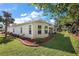 Landscaped backyard with lush grass, manicured beds, and a covered patio, creating an inviting outdoor space at 10282 Julia Isles Ave, Oxford, FL 34484