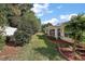 Lush backyard featuring green grass, mature trees, and mulch beds surrounded by brick edging at 10282 Julia Isles Ave, Oxford, FL 34484
