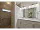 Bathroom featuring double vanity sinks, tiled shower, and modern lighting fixtures at 10282 Julia Isles Ave, Oxford, FL 34484
