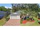Well-maintained home featuring palm trees, a brick driveway, and a meticulously landscaped front yard at 10282 Julia Isles Ave, Oxford, FL 34484