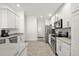 Contemporary kitchen with stainless steel appliances, marble countertops and white cabinetry at 10282 Julia Isles Ave, Oxford, FL 34484