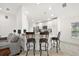 Modern kitchen with stylish bar seating and seamless flow to the living area at 10282 Julia Isles Ave, Oxford, FL 34484