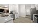 Well-lit kitchen featuring stainless steel appliances and white cabinetry, with easy access to other rooms at 10282 Julia Isles Ave, Oxford, FL 34484