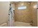 Tiled shower over tub with shower curtain and window at 10282 Julia Isles Ave, Oxford, FL 34484