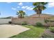 Landscaped backyard featuring a concrete patio, vibrant green grass, and tropical palm trees at 1084 Becker Ave, The Villages, FL 32163