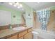 Well-lit bathroom featuring a shower-tub combo with light green walls at 1084 Becker Ave, The Villages, FL 32163