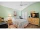 Bright bedroom featuring light green walls, ceiling fan, and a double bed at 1084 Becker Ave, The Villages, FL 32163
