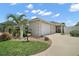 Charming single-story home featuring a well-maintained lawn, palm tree, and attached two-car garage with a paved driveway at 1084 Becker Ave, The Villages, FL 32163