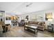 Open-concept living area with a comfortable sofa, wood-look floors, and views into the kitchen and dining area at 1084 Becker Ave, The Villages, FL 32163