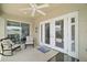 Covered patio with ceiling fan and white framed glass doors at 1084 Becker Ave, The Villages, FL 32163