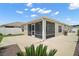 The back exterior featuring a screened lanai and concrete patio at 1084 Becker Ave, The Villages, FL 32163