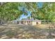 A backyard with a dart board, screen patio, and lush green trees at 10851 Lantana Crst, Clermont, FL 34711