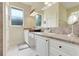 Well-lit bathroom with a double vanity, granite countertops, and white cabinets at 10851 Lantana Crst, Clermont, FL 34711