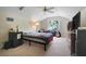Bedroom with neutral walls, ceiling fan, window view and entertainment center at 10851 Lantana Crst, Clermont, FL 34711
