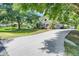 Exterior shot showcasing the house, long driveway, mature landscaping, and well-maintained lawn at 10851 Lantana Crst, Clermont, FL 34711