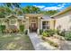 Inviting entrance with stone columns, manicured landscaping, and a decorative front door at 10851 Lantana Crst, Clermont, FL 34711