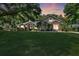 Charming single-story home with a large front lawn and stone facade accents at sunset at 10851 Lantana Crst, Clermont, FL 34711