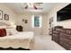 Bright main bedroom with a tray ceiling, ceiling fan, furniture, and a large window with elegant curtains at 10851 Lantana Crst, Clermont, FL 34711